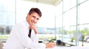 man sitting at desk leaning on chin
